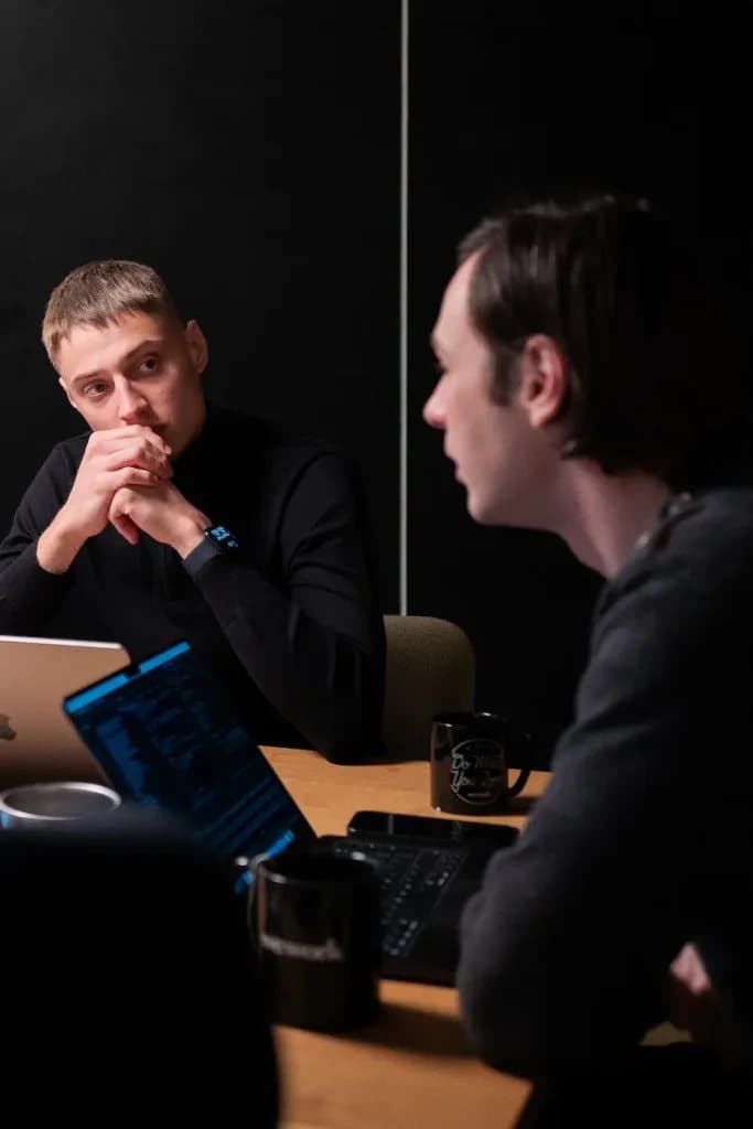 Two members of the team in conversation at a meeting table